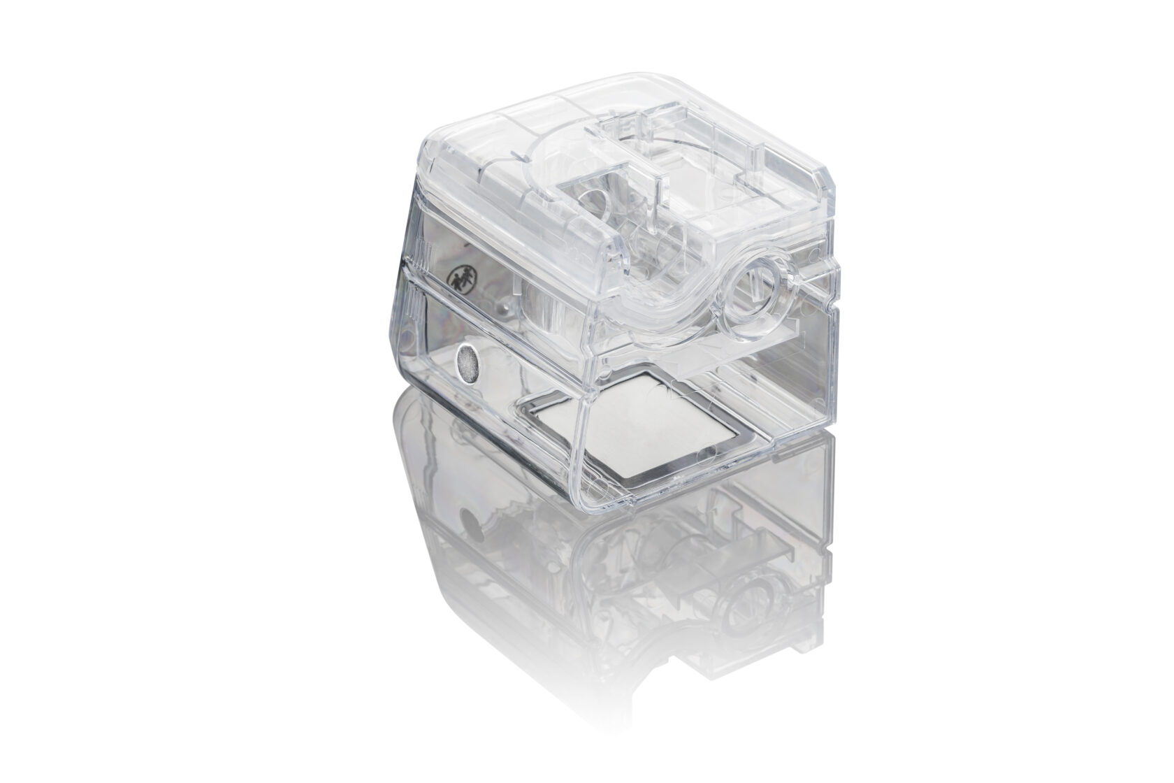 Transparent plastic humidifier chamber with reflection on a white background.