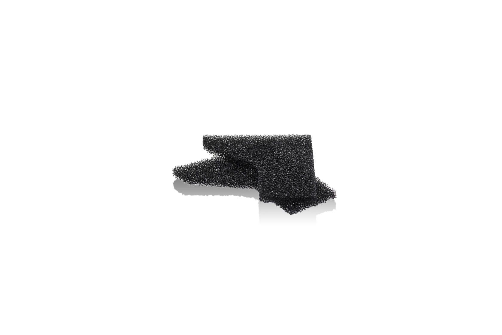 Two pieces of black porous foam stacked on a white background.