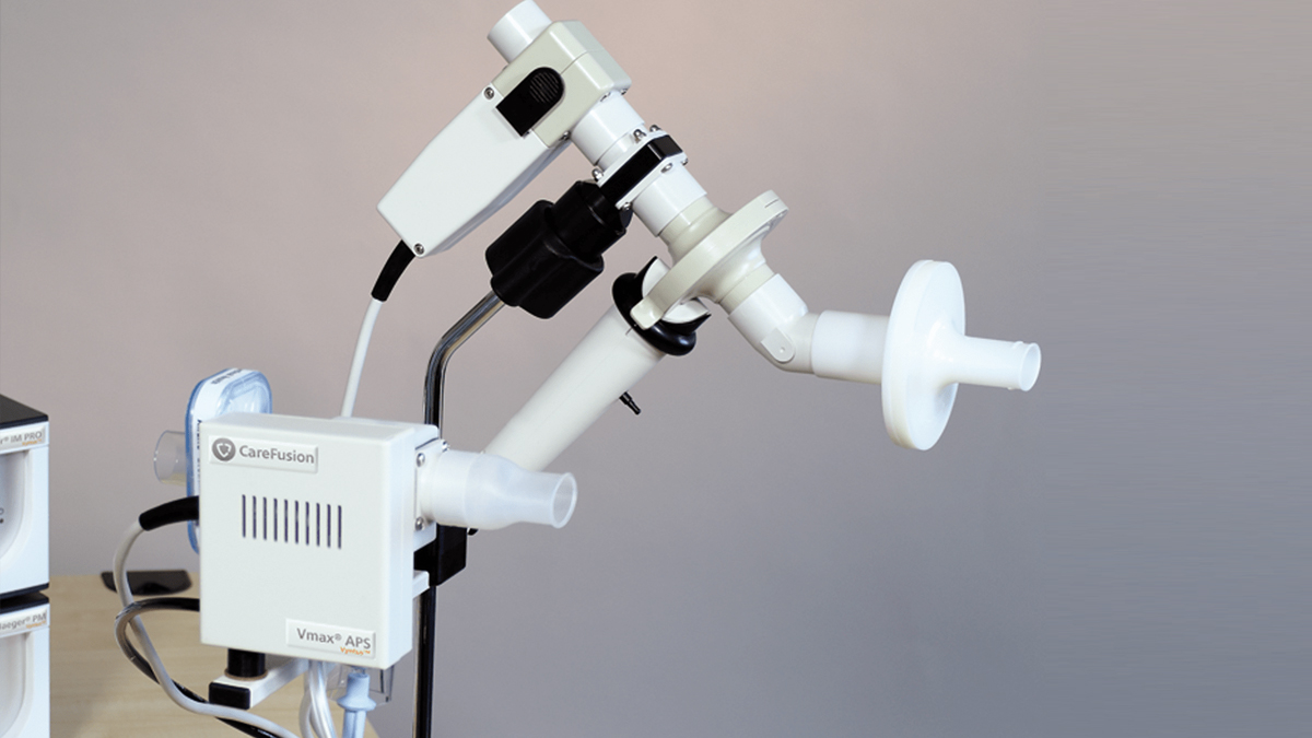A spirometer device with a CareFusion Vmax APS unit and breathing tubes on a stand against a neutral background.