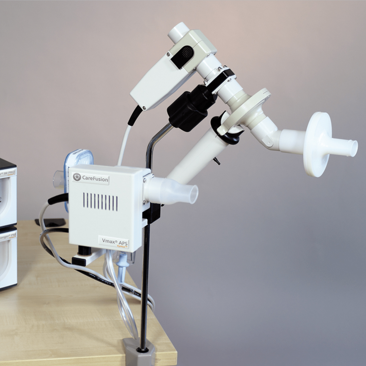 Spirometry lung function testing device setup on a table with mouthpiece and tubes attached.