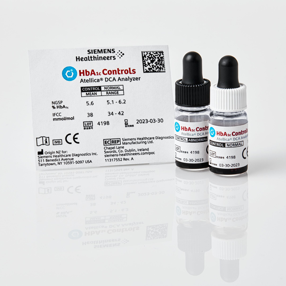 Two small vials labeled "HbA1c Controls" with droppers, beside a Siemens Healthineers information card.