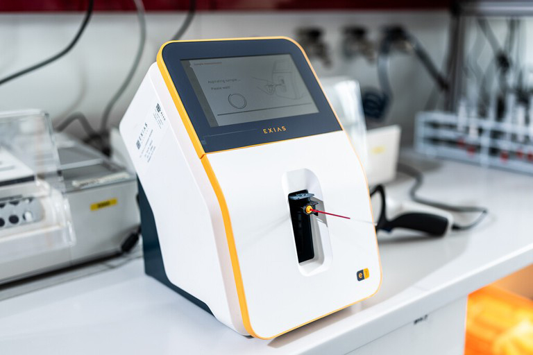 Medical analysis device with a display screen and a sample holder in a laboratory setting.
